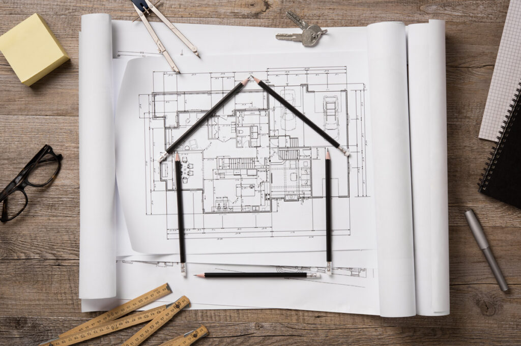 Floor plan blueprints of an El Paso new build with pencils outlining the shape of a home.
