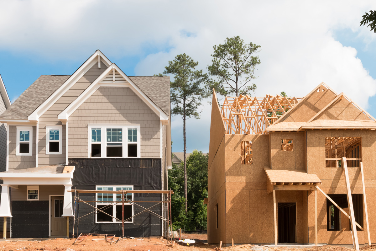 Two new construction homes at different building stages in El Paso.